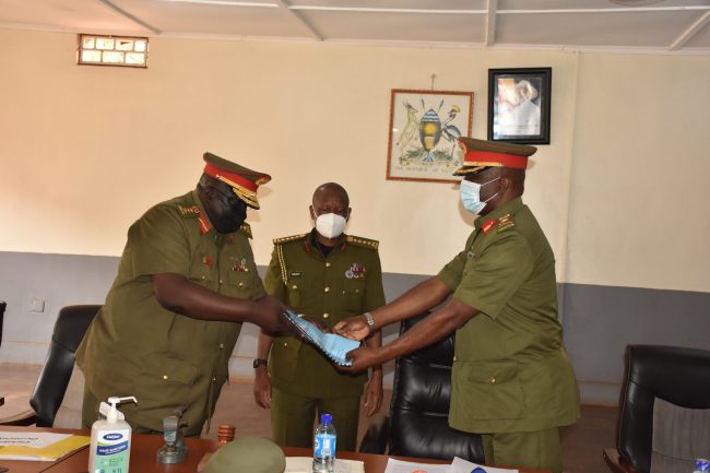 Outgoing Court Marshal Chairman Gen Guti hands over afile to the incoming Chairman Brig Gen Robert Mugabe as CDF Gen Mbadi looks on