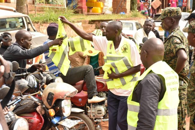 Chairman Boda boda Ibanda municipality giving reflector jackets to his members at Shell Stage