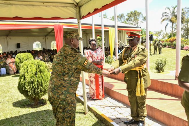 CDF Gen Muhoozi Kainerugaba giving discharge certificate to Rtd Col Sam Ngobi at the retirement ceremony of senior officers at MoDVA Hqrs