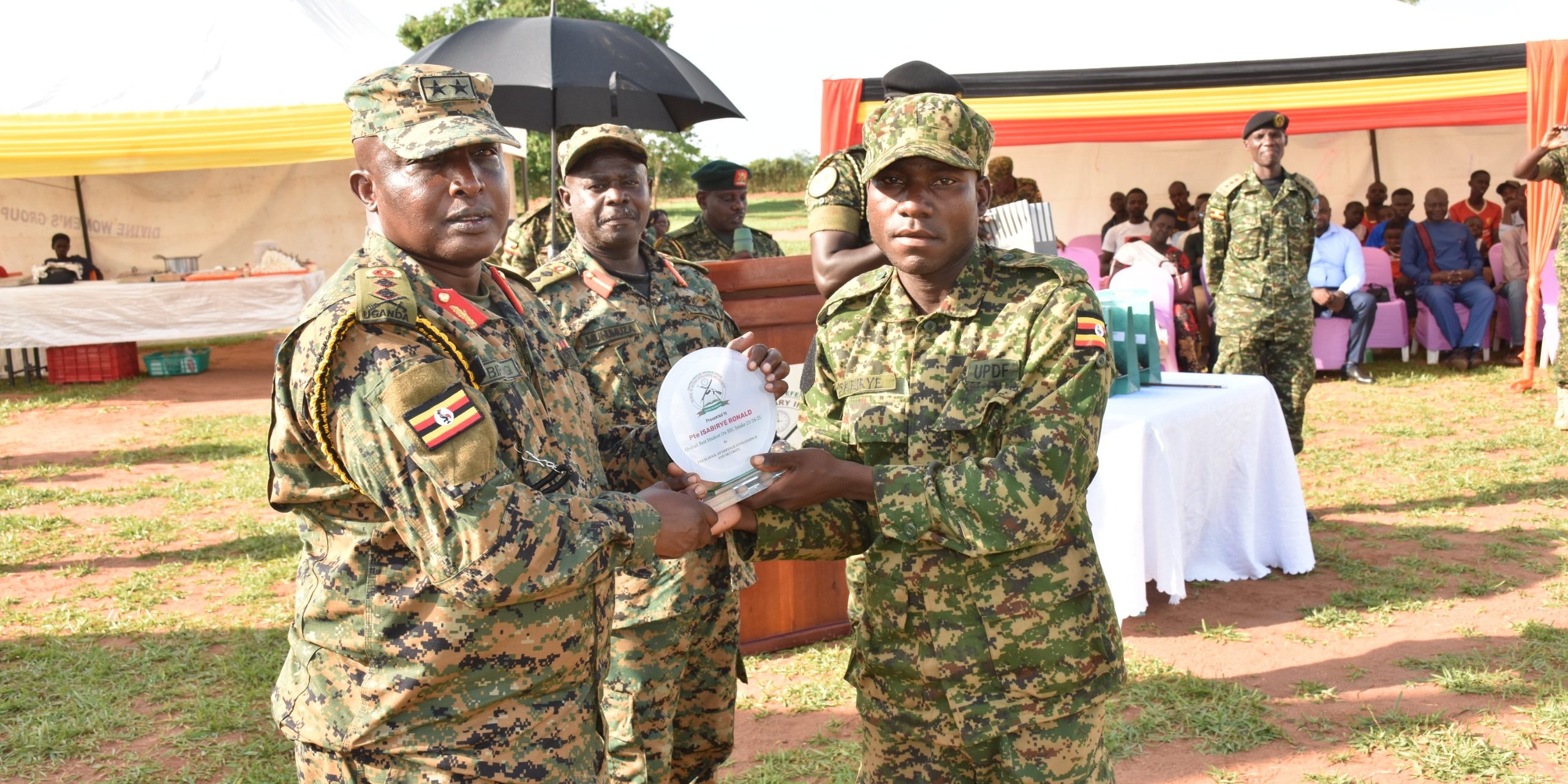 GEN JAMES BIRUNGI AWARDING THE OVERALL BEST STUDENT PTE ISABIRYE RONALD AT THE BASIC INTELLIGENCE COURSE PASSOUT HELD AT MIGYERA