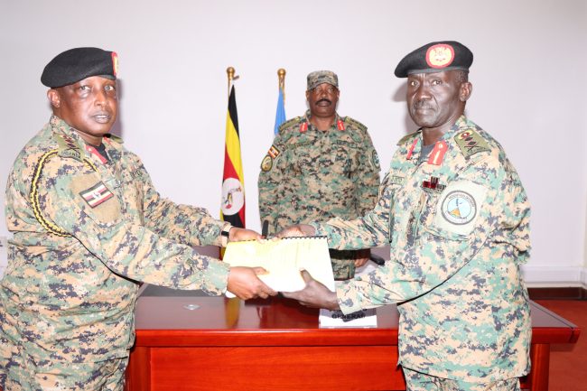 Maj Gen James Birungi (L) handing over instruments of power to new DIS Chief Maj Gen Richard Otto while Lt Gen Kayanja Muhanga (C) is witnessing