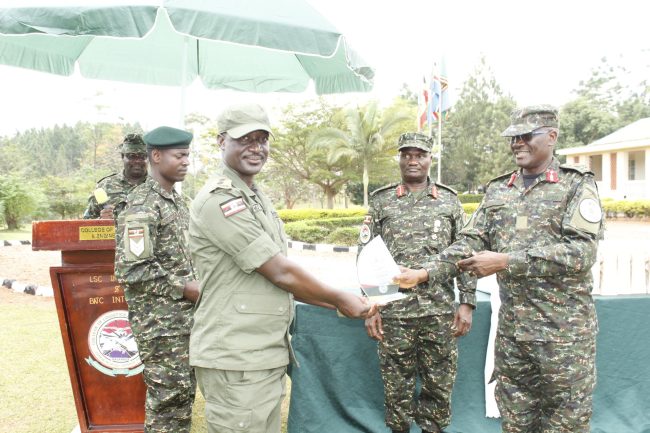 Capt Pius Katumuhimbise Mutatiina the best overall student recieving a sovenior from Brig Gen Kefa Nangeso