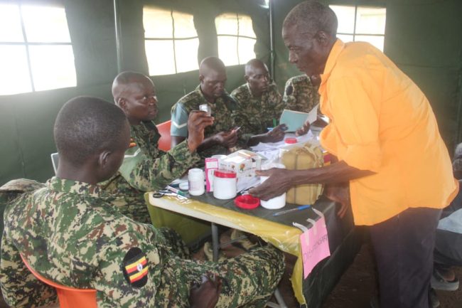 an elder receiving some medicine from UPDF medical officer