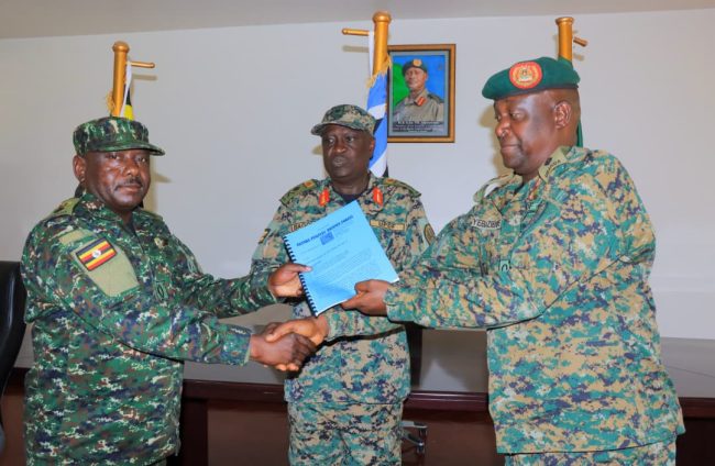 Brig Gen Chris Bagonza (centre) looks on as Col Joab Yebazibwe (right) hands over a report to Lt Col Yona Tumuvamye (left) during a handover ceremony at the Land Force Headquarters in Bombo..jpg