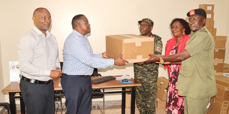 Col Dr Francis Bakehena (C) Receiving the gene expert machine..JPG