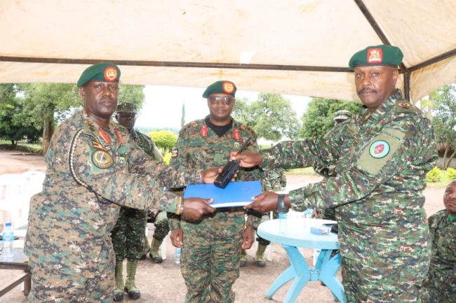 L-R Col Bainomugisha handsover instrument of authority to Lt Col Nahamya as Maj Gen Busizoori looks on (2).JPG