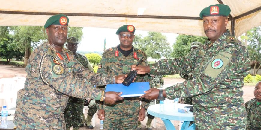 L-R Col Bainomugisha handsover instrument of authority to Lt Col Nahamya as Maj Gen Busizoori looks on (2).JPG