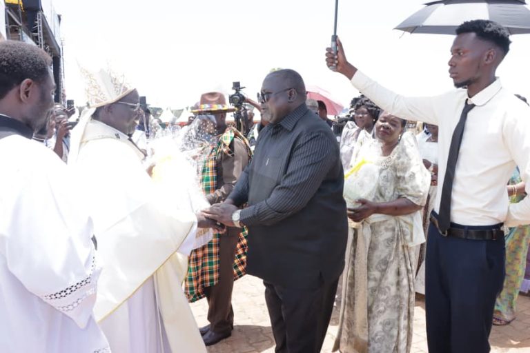 ArchiBishop Gulu Catholic Diocese main cerebrant recieves offetory gifts from Lt Gen Rtd Otema awanyi during the thanks giving at kaunda grounds.JPG
