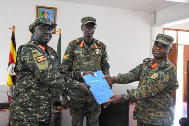 Col Asaba Benon out going DPC (R) handing over the report to Col Anatoli Nuwagira (L) who is the in coming DPC being witnessed by Director Human Resouce Land Force Brig Gen Emmanuel Ewama.jpg