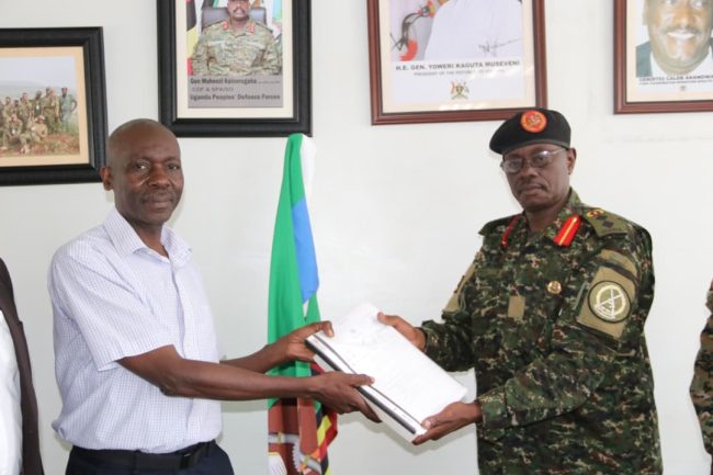 L-R Mag Gen Rtd D Wakaalo recieves instruments of authority from Col V Opera.JPG