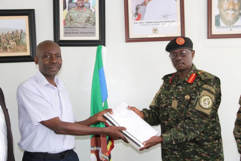 L-R Mag Gen Rtd D Wakaalo recieves instruments of authority from Col V Opera.JPG